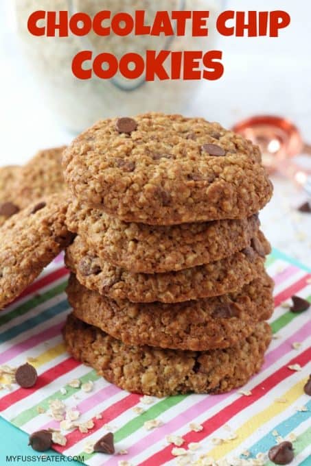 Healthier Chocolate Chip cookies stacked up on a multicolored striped napkin.