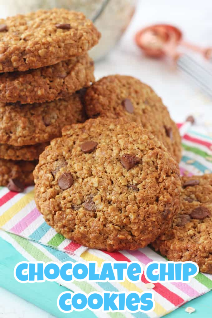 a stack of healthier chocolate chip cookies on colourful striped napkins on a blue chopping board.
