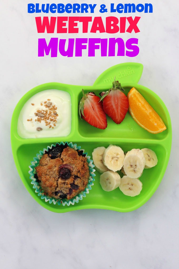 A Blueberry & Lemon Weetabix Muffin served on a green Munchkin divided plate with a portion of greek yogurt and freshly chopped strawberry, orange and banana.