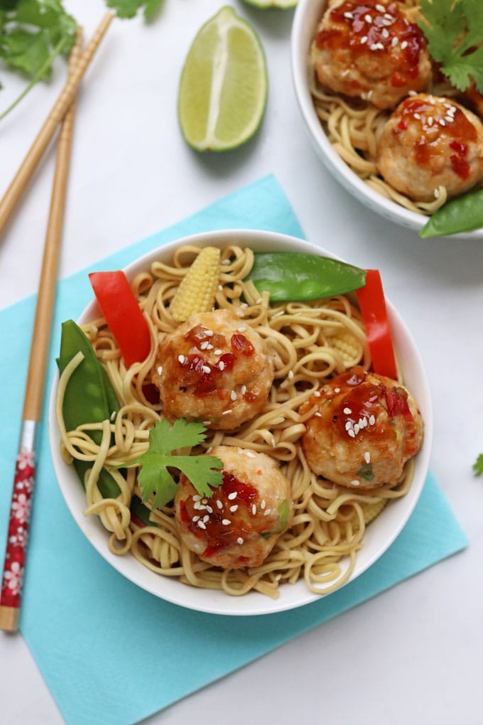 Two small bowls of Sweet Chilli Chicken Meatballs served with noodles, red peppers, mini sweetcorn and mage tout.