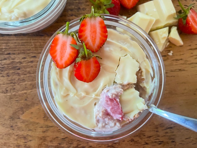 Easy Make-Ahead Breakfast Recipes & Ideas For Kids - Strawberry and White Chocolate Overnight Oats in a glass ramekin topped with chopped fresh strawberries