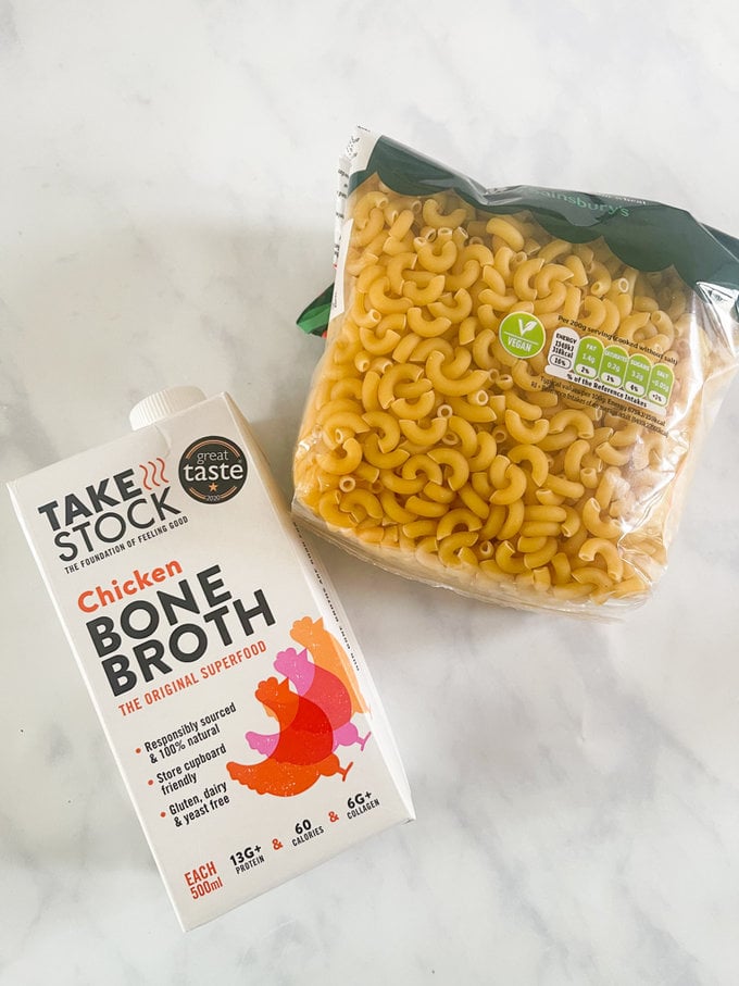 Photo showing ingredients laid out on worktop. Pack of pasta and carton of chicken bone broth.