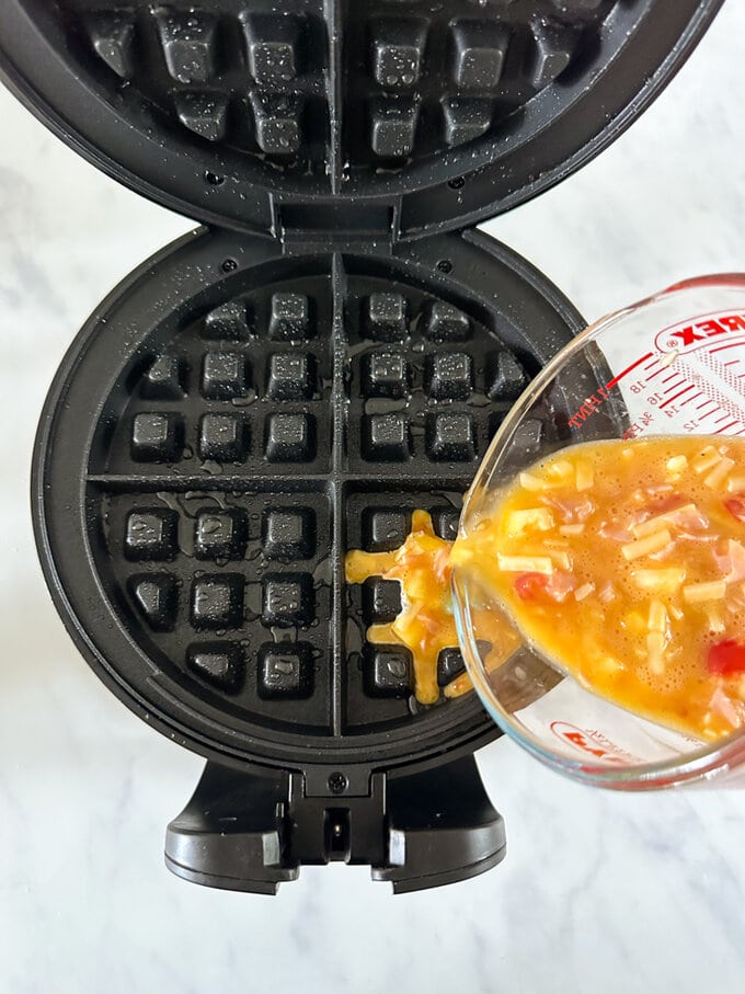 Ingredients being poured into the waffle maker.