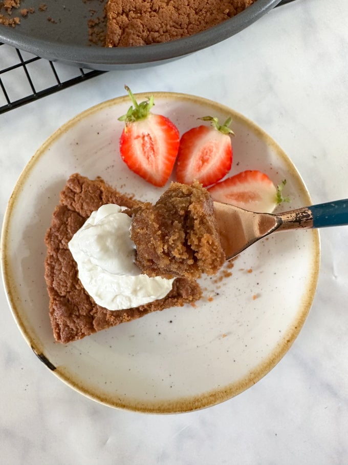 cake served on a small white plate and garnished with fresh berries and a big dollop of Greek yogurt.