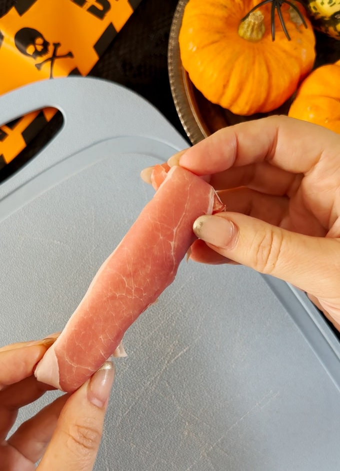 Ham now fully covering cheese string.