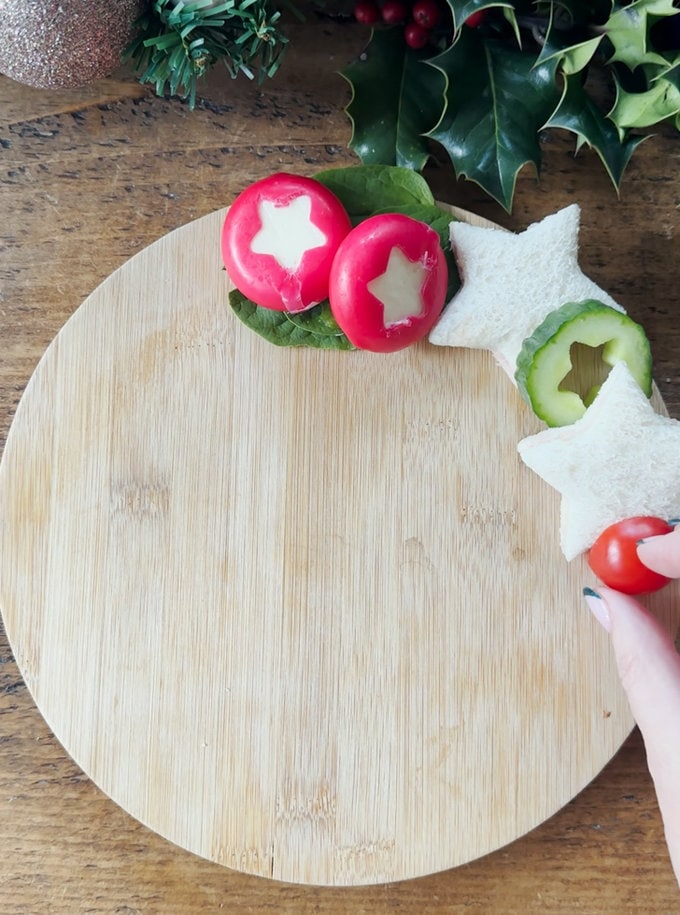 Christmas Sandwich Wreath being arranged on a wooden chopping board.
