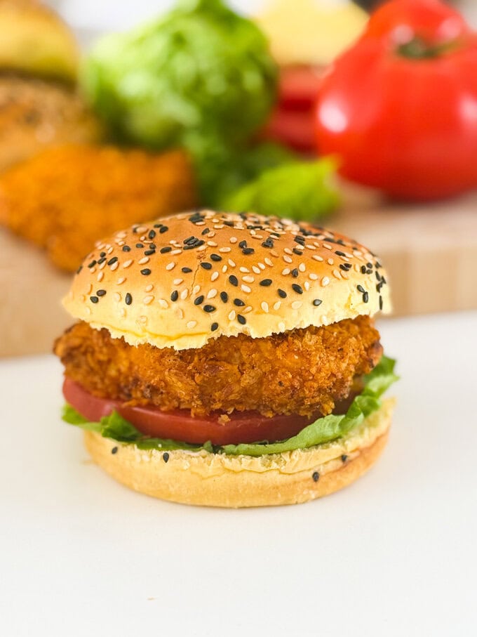 The most delicious homemade crispy chicken burgers. Made with a cornflake coating for extra crunch and oven baked to keep them super healthy. Served in a seeded burger bun with fresh slices of tomato and lettuce leaves.