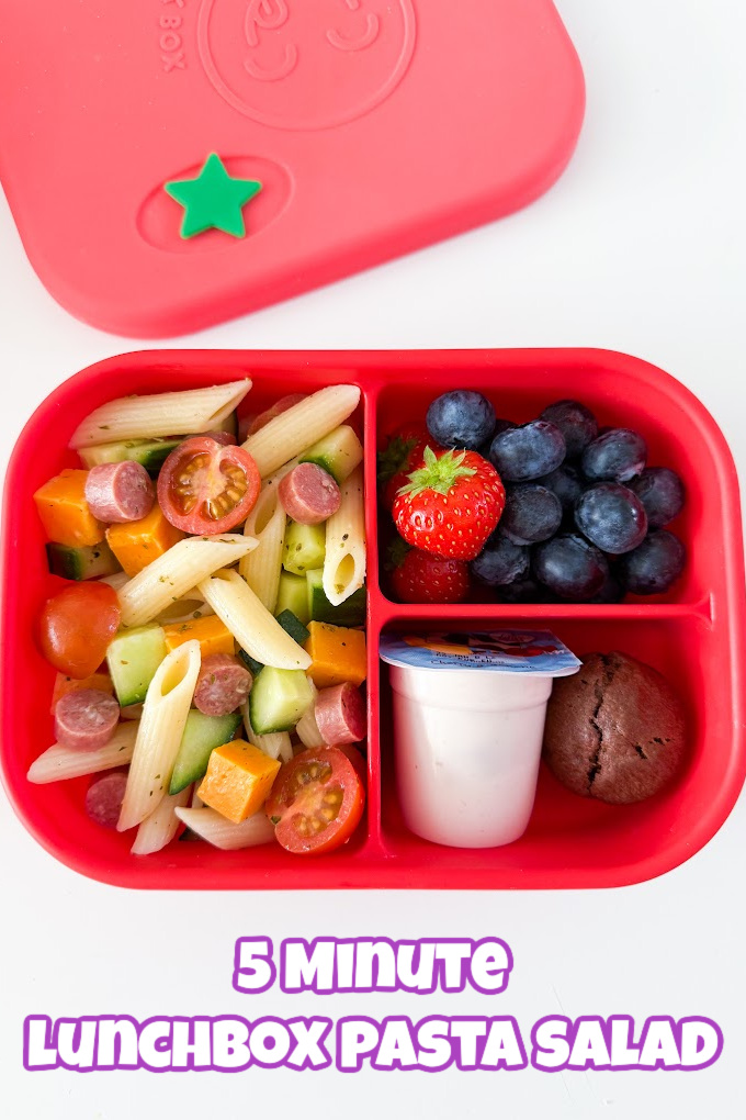 5 Minute Lunchbox Pasta Salad served in a bright red lunch box with fresh berries, yogurt and a sweet treat.