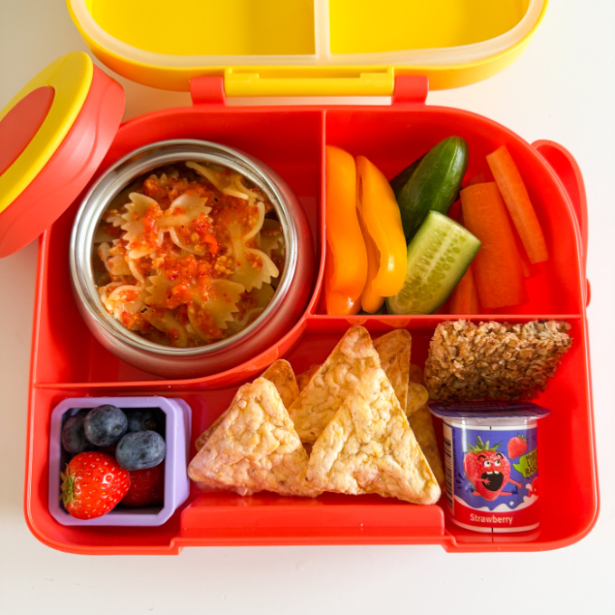 Red Pepper Pasta served in a bright red hot & cold lunch box with sliced,fresh veggies.