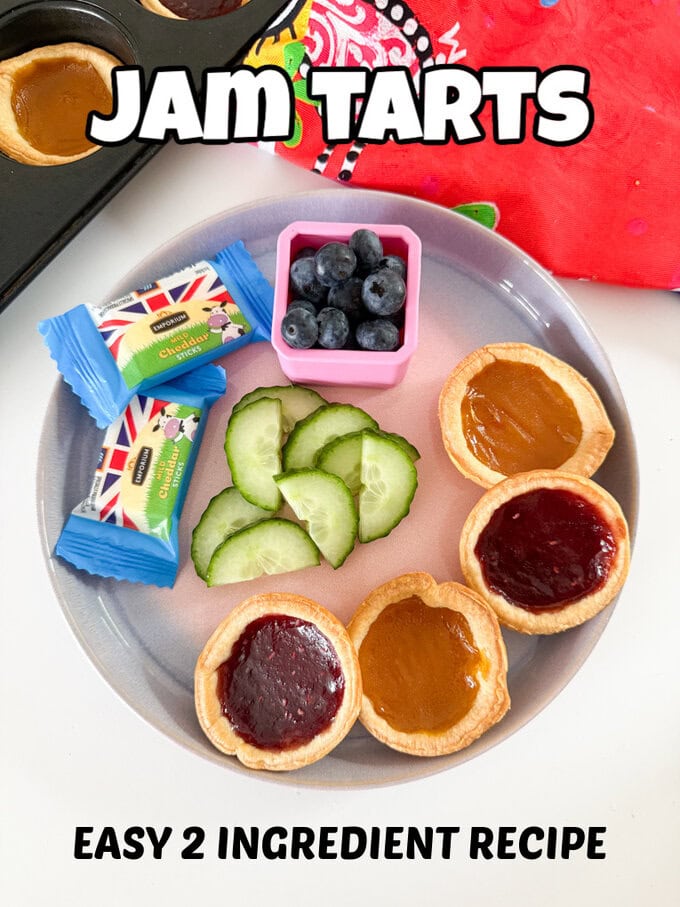 Four Jam Tarts arranged on a plate and served with fresh berries and cucumber slices and cheese chunks.